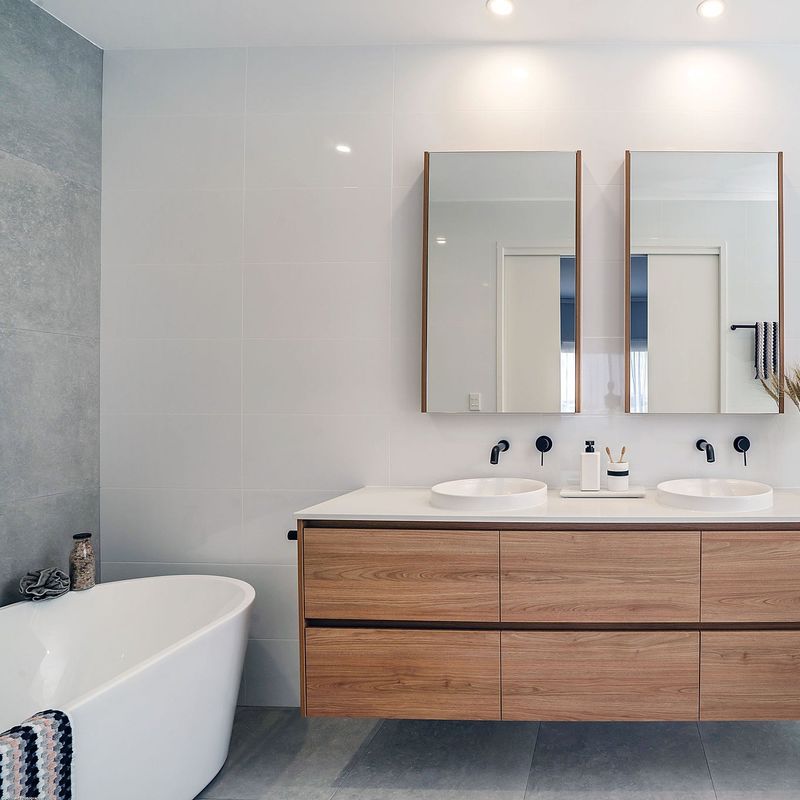 Piccolo vaschetto a parete a sospensione per bagno con vasca da bagno e specchio